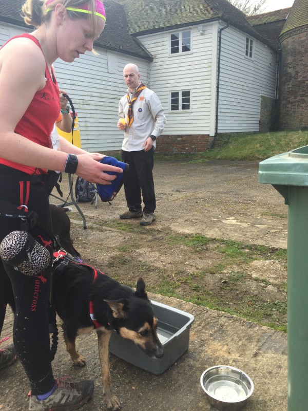 A lady with her dog stopping for a drink of water